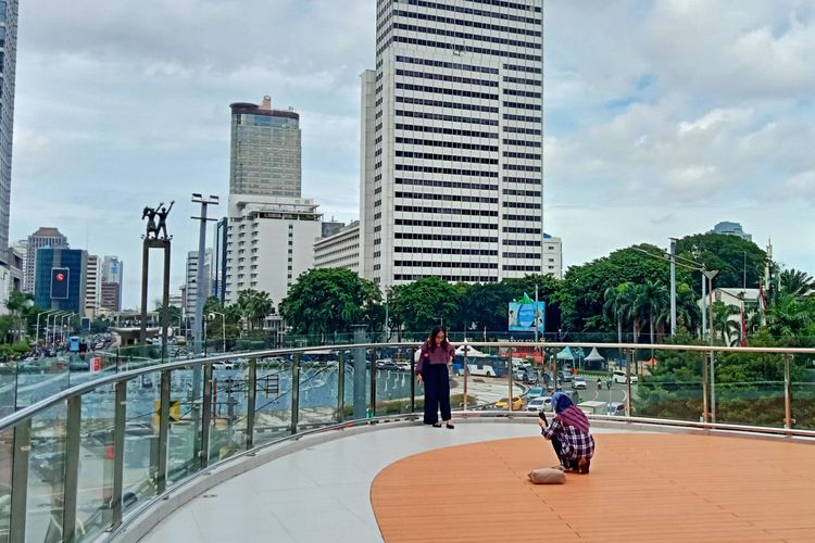 Pengunjung Halte Tosari sedang berfoto di bagian anjungan dengan landskap pemandangan Patung Selamat Datang.