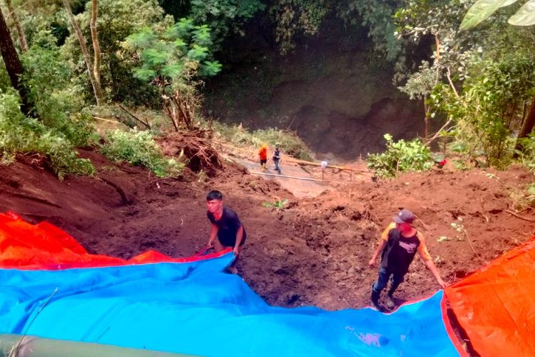 Jajaran BPBD Kabupaten Malang memasang terpal tebing sisa longsor di kawasan Desa Puspo, Kecamatan Puspo, Kabupaten Pasuruan, Selasa (29/3/2023).