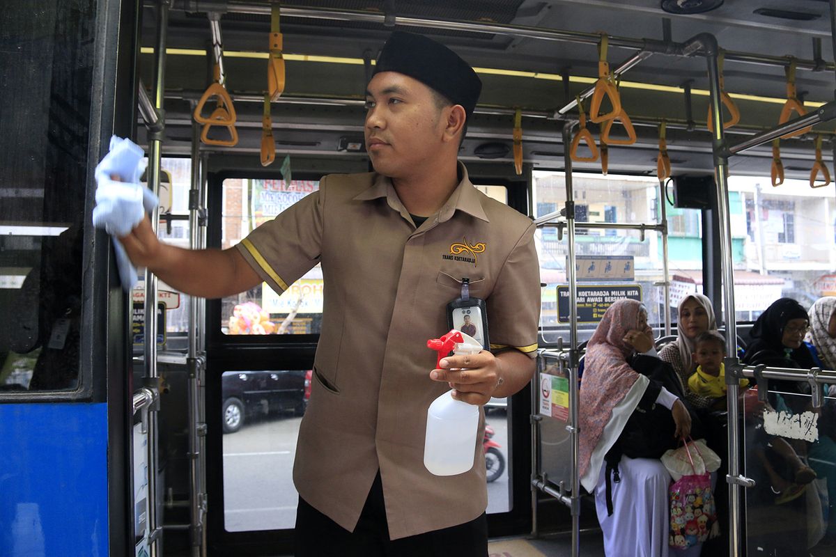 Pramugara Bus Transkoetaraja sedang membersihkan benda-benda yang sering disentuh oleh penumpang dengan menggunakan cairan alkoho. Kamis (05/03/2020). Sterilisasi fasilita BUS penumpang dengan layanan geratis di Kota Banda Aceh ini disosialisasikan oleh petugas Dinas Perhubungan  Provinsi Aceh sejak dua hari ini untuk mencegah agar wabah vius corona tidak tersebar di Aceh.