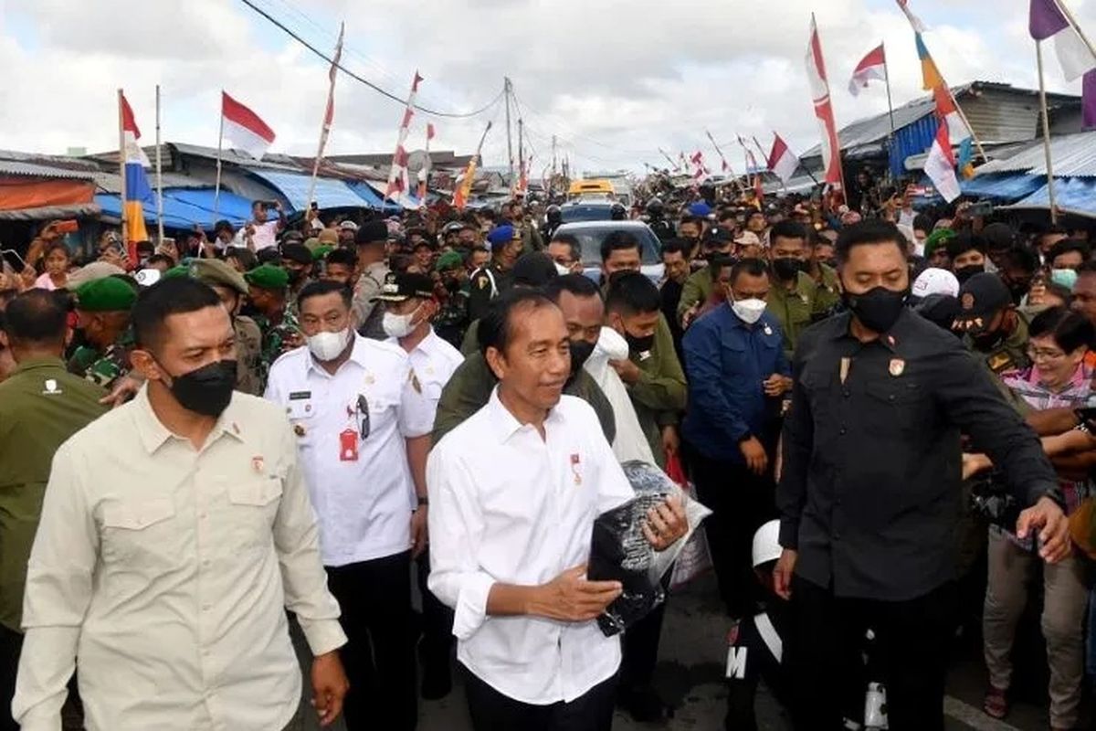 Presiden Joko Widodo menyerahkan kaos kepada warga saat mengunjungi Pasar Olilit di Kabupaten Kepulauan Tanimbar, Maluku, Jumat (2/9/2022). (ANTARA/HO-Biro Pers Sekretariat Presiden)