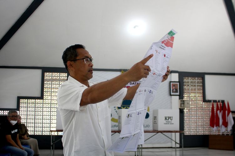Pelatih Persikabo 1973 Aji Santoso saat mengecek surat suara sebelum melaksanakan pencoblosan untuk Pemilu 2024 di Balai RW tempat tinggalnya di Malang, Jawa Timur, Rabu (14/2/2024) siang. 