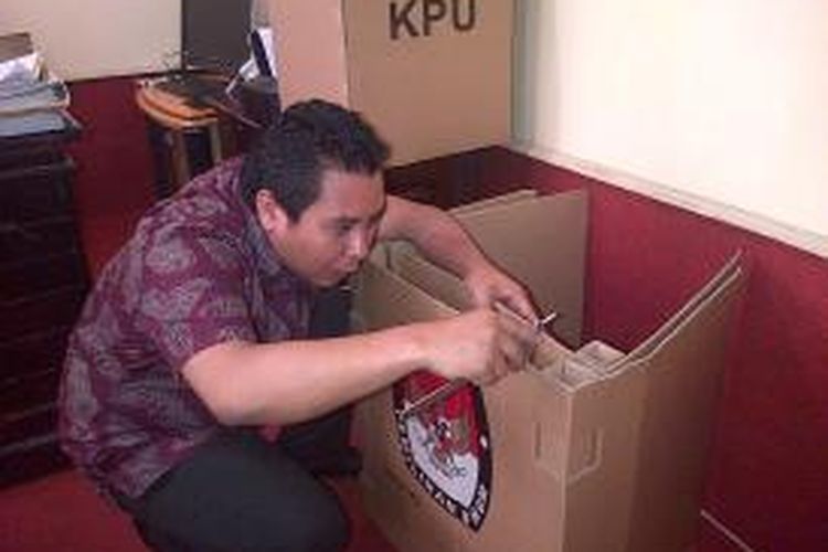 Ketua KPU Sulawesi Tenggara, Hidayatullah mengukur ketebalan bilik suara pemilu 2014 yang terbuat dari kardus. Hasil logistik pemilu itu tidak sesuai dengan spesifikasi yang ditentukan yakni setebal minimal 6 milimeter.