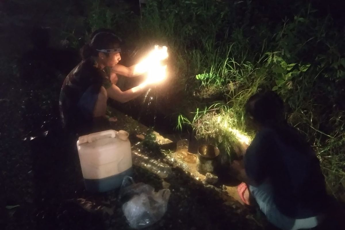 Warga Blora mengambil minyak mentah di selokan pada Selasa (15/3/2022) malam.