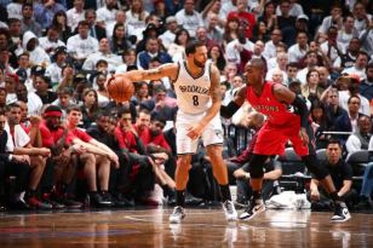 Pebasket Brooklyn Nets, Deron Williams (kiri) menjaga bola dari pemain Toronto Raptors pada laga keenam babak play-off Wilayah Timur di Barclays Center, Jumat (2/5/2014). Nets menang 97-83.