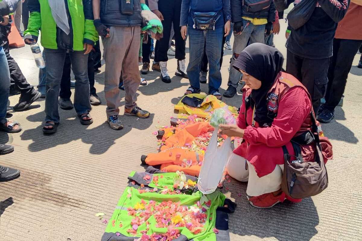 Pengemudi Ojol di Banten saat menaburkan bunga sebagai tanda kehilangan rekan seperjuangan Affan Kurniawan di Mapolda Banten, Kota Serang, Jumat (29/8/2025).