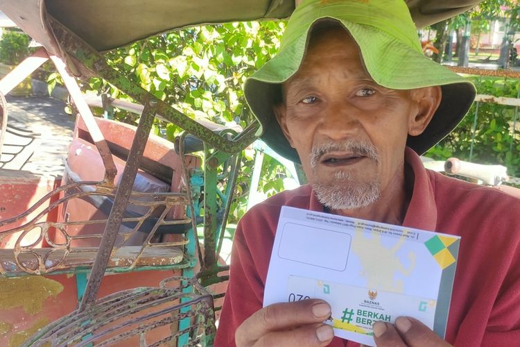 Herdi Wanto (62) tukang becak mangkal di Gawok, Wates, menerima santunan menjelang lebaran di Kabupaten Kulon Progo, Daerah Istimewa Yogyakarta. Ia menganggapnya seperti THR.