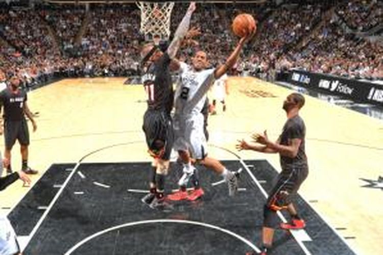 Pebasket San Antonio Spurs Kawhi Leonard (putih) mencoba memasukkan bola saat menghadapi Miami Heat di the AT&T Center, Kamis (6/3/2014). Spurs menang 111-87.