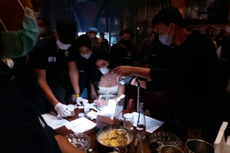 Selebgram Millen Cyrus (tengah) jalani tes urine saat terjaring razia protokol kesehatan yang dilaksanakan oleh Direktorat Reserse Narkoba Polda Metro Jaya di Bar Brotherhood Gunawarman, Kebayoran Baru, Jakarta Selatan, Minggu dini hari (28/2/2021).  