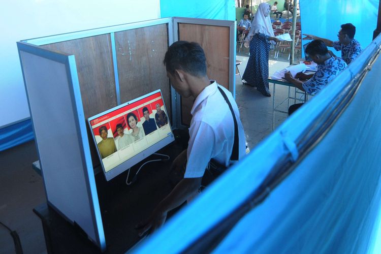 Warga mengamati foto calon kepala desa pada layar komputer saat Pemilihan Kepala Desa (Pilkades) berbasis elektronik atau e-voting di Kantor Desa Bendosari, Sawit, Boyolali, Jawa Tengah, Sabtu (29/6/2019).