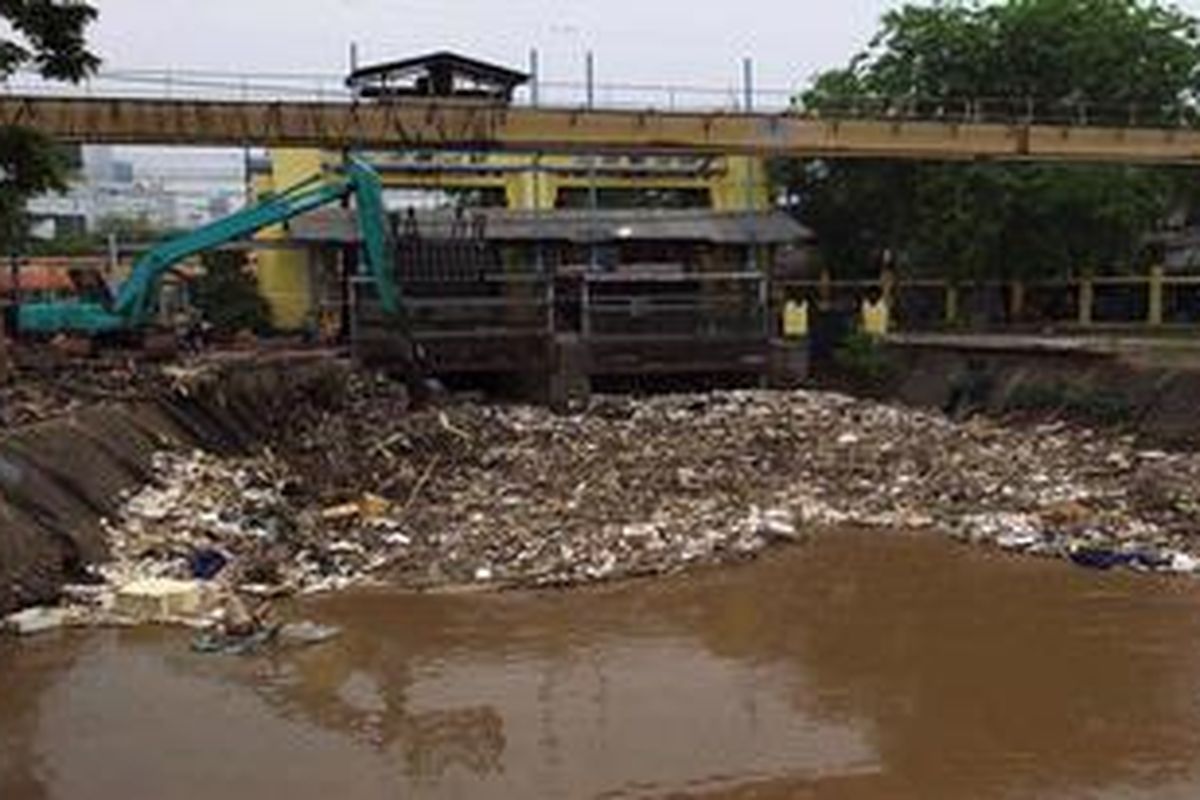 Pekerja menunggu truk untuk mengangkut sampah yang menumpuk di Pintu Air Manggarai, Jakarta Selatan, Senin (22/10/2012). Sampah tersebut menumpuk karena hujan mulai turun dan terbawa oleh aliran Sungai Ciliwung.
