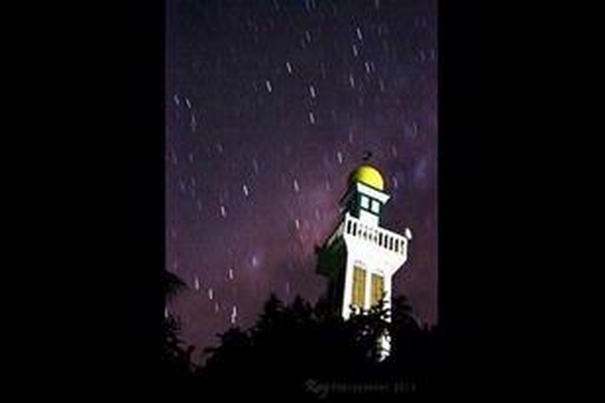 Bintang tampak berwujud garis, seperti titik-titik air hujan. Dengan latar langit malam, galaksi Bimasakti dan sebuah masjid di Pulau Pramuka, Minggu (3/7/2011).