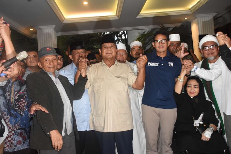 Capres nomor urut 02 Prabowo Subianto (tengah) bersama Cawapres Sandiaga Uno dan petinggi partai pendukung mengangkat tangan saat mendeklarasikan kemenangannya pada Pilpres 2019 kepada awak media di kediaman Kertanegara, Jakarta, Kamis (18/4/2019). Prabowo kembali mendekalarasikan kemenangannya versi real count internal BPN sebesar 62 persen.