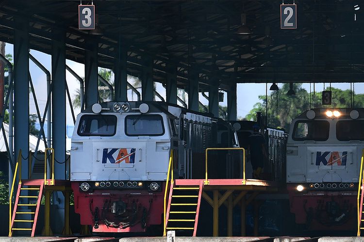 Pekerja berjalan di samping lokomotif di Depo Cipinang, Jakarta Timur, Minggu (21/3/2021). Kementerian Perhubungan menyatakan Depo Cipinang merupakan depo kereta api terbesar di Indonesia yang memiliki 28 jalur kereta, mampu merawat 144 lokomotif dan 120 gerbong kereta per hari serta dibangun di atas lahan seluas sembilan hektare dengan biaya hampir Rp500 miliar. ANTARA FOTO/Sigid Kurniawan/wsj.