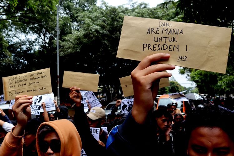 Ratusan suporter Arema FC menunjukkan suratnya saat menggelar aksi kirim Surat dari Aremania untuk Presiden Jokowi Menuntut Usut Tuntas Tragedi Kanjuruhan di Kantor Pos Kota Malang, Kamis (17/11/2022) siang.