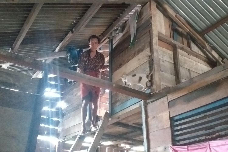 Satar (51), salah seorang korban banjir di Desa Tanjung Balam, Kecamatan Siak Hulu, Kabupaten Kampar, Riau, memperlihatkan tempat mengungsi yang dibuat di dalam rumahnya setinggi lebih kurang empat meter, Minggu (29/12/2019).