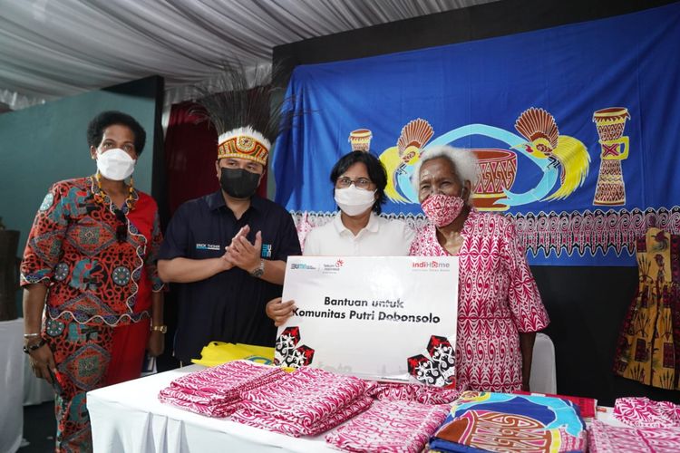 Direktur Consumer Service Telkom Venusiana (kedua dari kanan) menyerahkan simbolis bantuan untuk Komunitas Putri Dobonsolo yang diterima oleh pendiri Batik Papua ?Pondok Putri Dobonsolo? Mariana Ibo (paling kanan) serta disaksikan Menteri BUMN Erick Thohir (kedua dari kiri) dan Ketua Komunitas Seni & Budaya Papua Yakoba Womsiwor (paling kanan) di Jayapura, Minggu (3/10).

