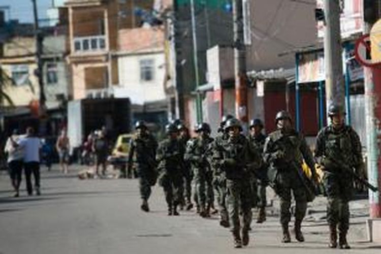 Sekelompok tentara Brasil berpatroli di permukiman kumuh Mare di kota Rio de Janeiro, Sabtu (5/4/2014), untuk menjamin keamanan pagelaran Piala Dunia 2014. Sebanyak 2.700 personel militer dikerahkan untuk menduduki permukiman kumuh paling berbahaya di kota Rio de Janeiro itu.
