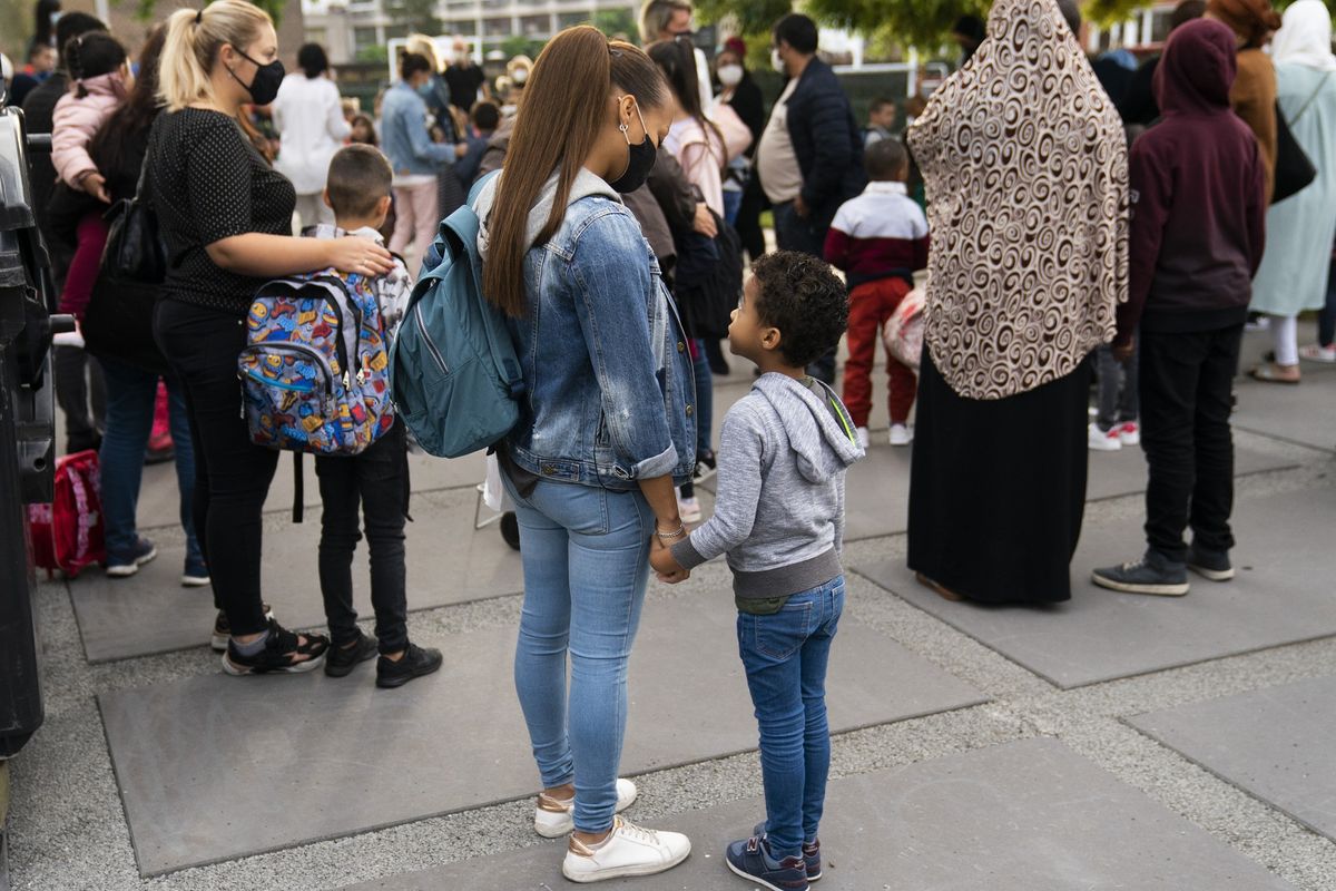 Anak-anak dan para orangtua memakai masker di hari pertama pembukaan kembali sekolah di Brussels, Belgia, pada Selasa (1/9/2020).