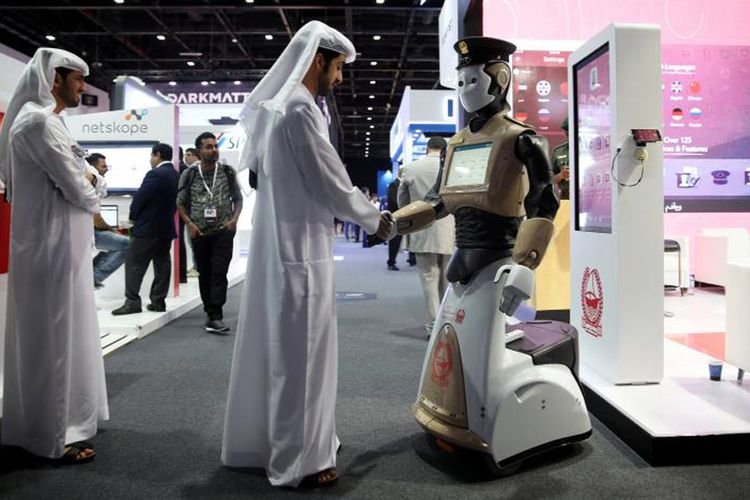 Seorang pengunjung berjabat tangan dengan seorang polisi robot pada pembukaan Pameran dan Konferensi Keamanan Informasi Teluk ke-4 (GISEC) di Dubai, Uni Emirat Arab, 22 Mei 2017.  
