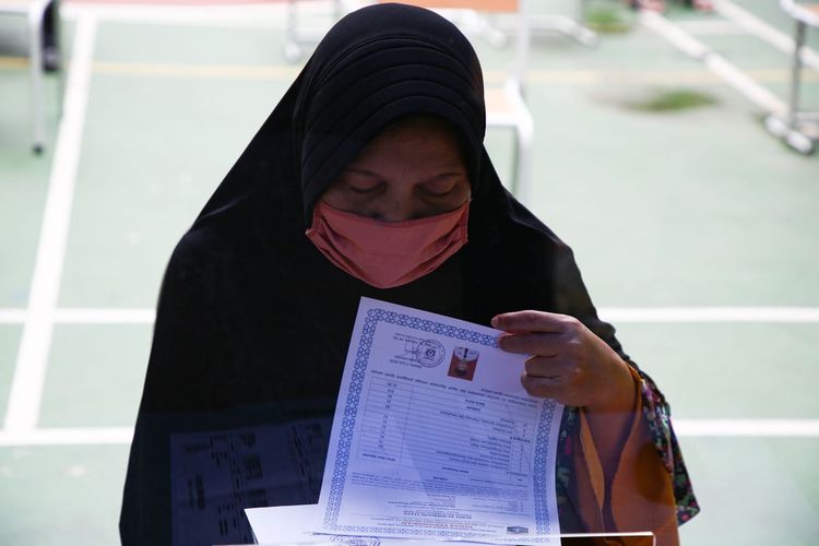 Orangtua siswa memeriksa dokumen anaknya saat melapor di posko penerimaan peserta didik baru (PPDB) SMK Negeri 15, Jakarta Selatan, Selasa (23/6/2020).