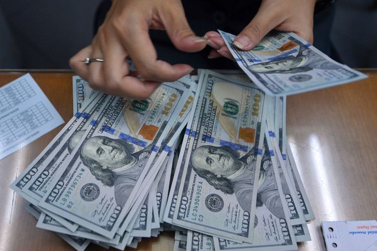 Petugas menghitung pecahan dolar Amerika di salah satu gerai penukaran mata uang di Kwitang, Jakarta Pusat, Selasa (8/5/2018). Nilai tukar rupiah terhadap dolla AS yang ditransaksikan pada Selasa (8/5/2018) ditutup melemah 51 poin atau 0,36 persen ke level Rp14.052 per dollar AS.