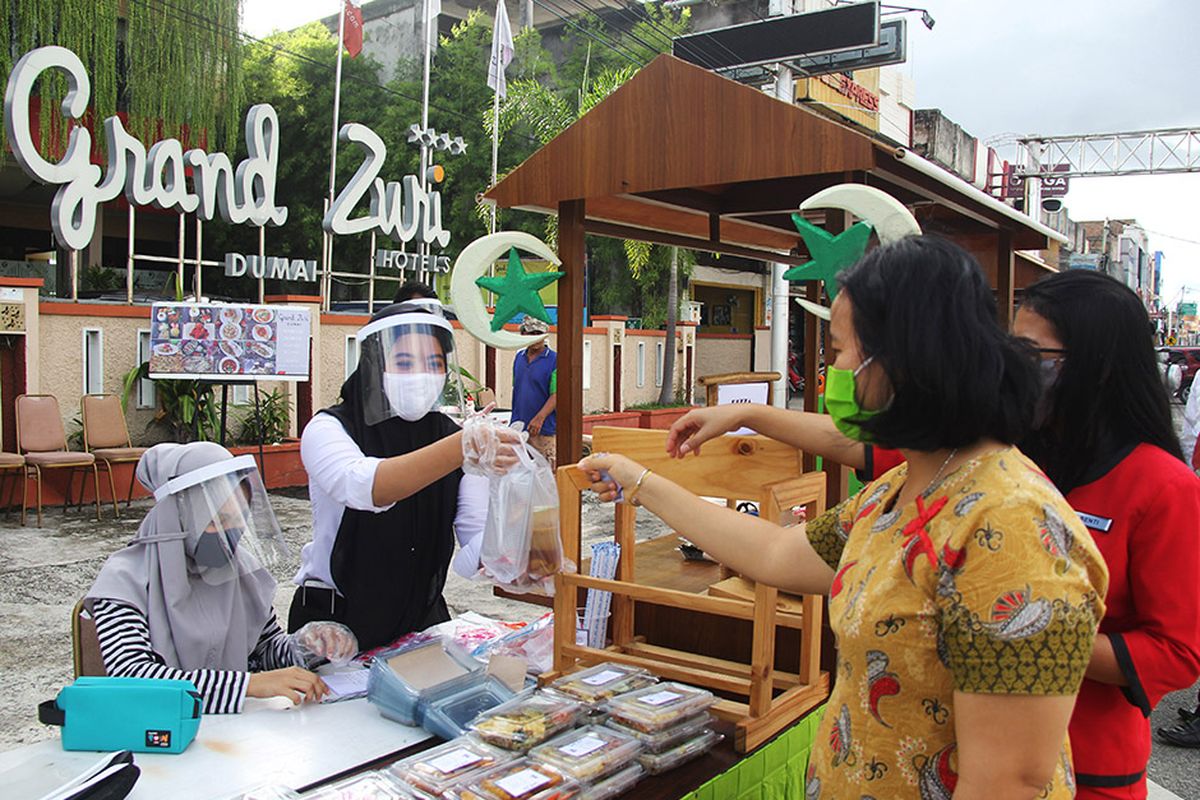 Pekerja hotel melayani pembeli takjil di Kota Dumai, Dumai, Riau, Rabu (13/5/2020). Pengusaha hotel di Kota Dumai memiliki kiat untuk menambah pendapatannya di masa pandemi COVID-19 agar pekerjanya terhindar dari pemutusan hubungan kerja (PHK) dengan cara berjualan takjil dan menu buka puasa selama bulan Ramadhan.