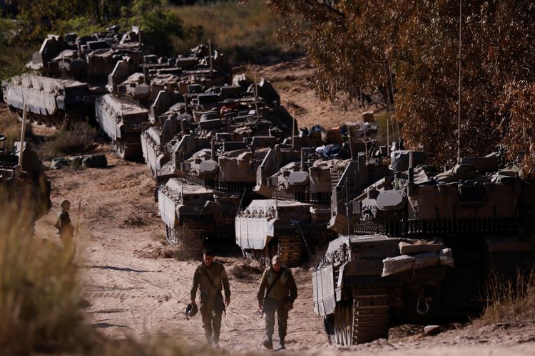 Israeli soldiers walk next to tanks near the border between Israel and the Gaza Strip on its Israeli side (15/5/2021)