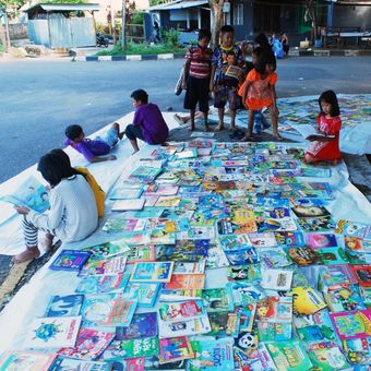 Anak-anak sedang membaca buku di kawasan Sebrang Pabayan, tepi Sungai Batang Arau, Padang, Sumatera Barat, Minggu (16/7/2017). Komunitas Baca Tanah Ombak meluncurkan kegiatan pustaka bergerak yang diberi nama Vespa Pustaka untuk menjangkau anak-anak di Kota Padang yang membutuhkan akses pendidikan lewat buku.