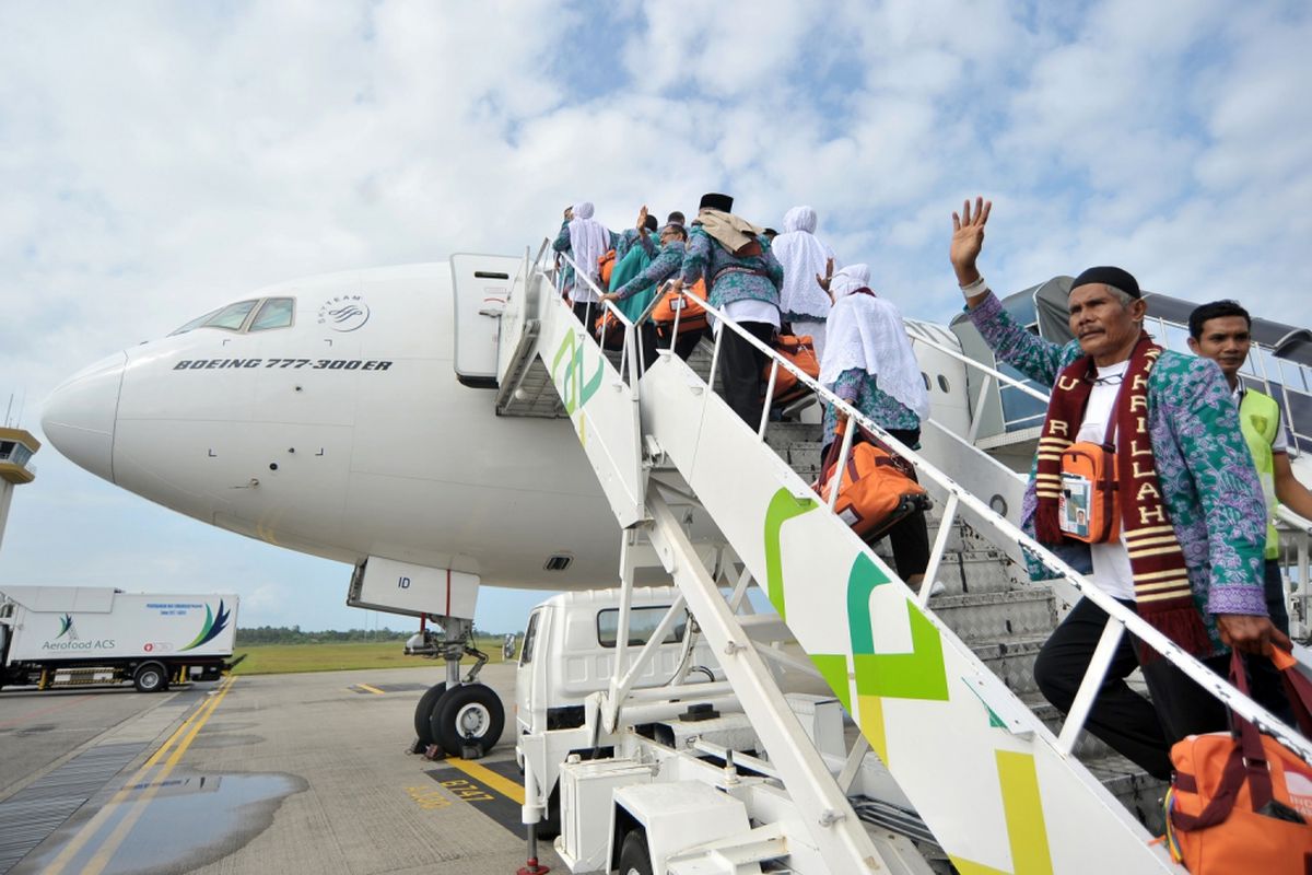 Jemaah calon haji asal Padang melambaikan tangan kepada keluarga mereka menjelang keberangkatan kloter pertama, di Bandara Internasional Minangkabau (BIM), Padangpariaman, Sumatra Barat, Jumat (28/7/2017). Embarkasi Haji Padang memberangkatkan 4.628 jemaah calon haji dari Sumbar, dan 1.641 orang dari Bengkulu yang terdiri atas 16 kelompok terbang (kloter). 