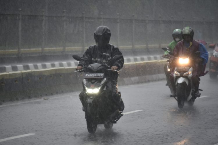 Ilustrasi pengendara sepeda motor menerabas hujan.