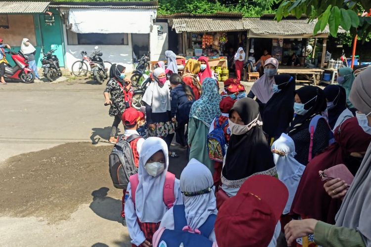Sejumlah siswa dan orangtua berkumpul di depan SD Negeri Bambu Apus 2, Pamulang, Tangerang Selatan, Senin (13/9/2021).
