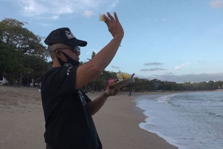 Made Supatra Karang melakukan ritual keagamaan di Pantai Kuta.