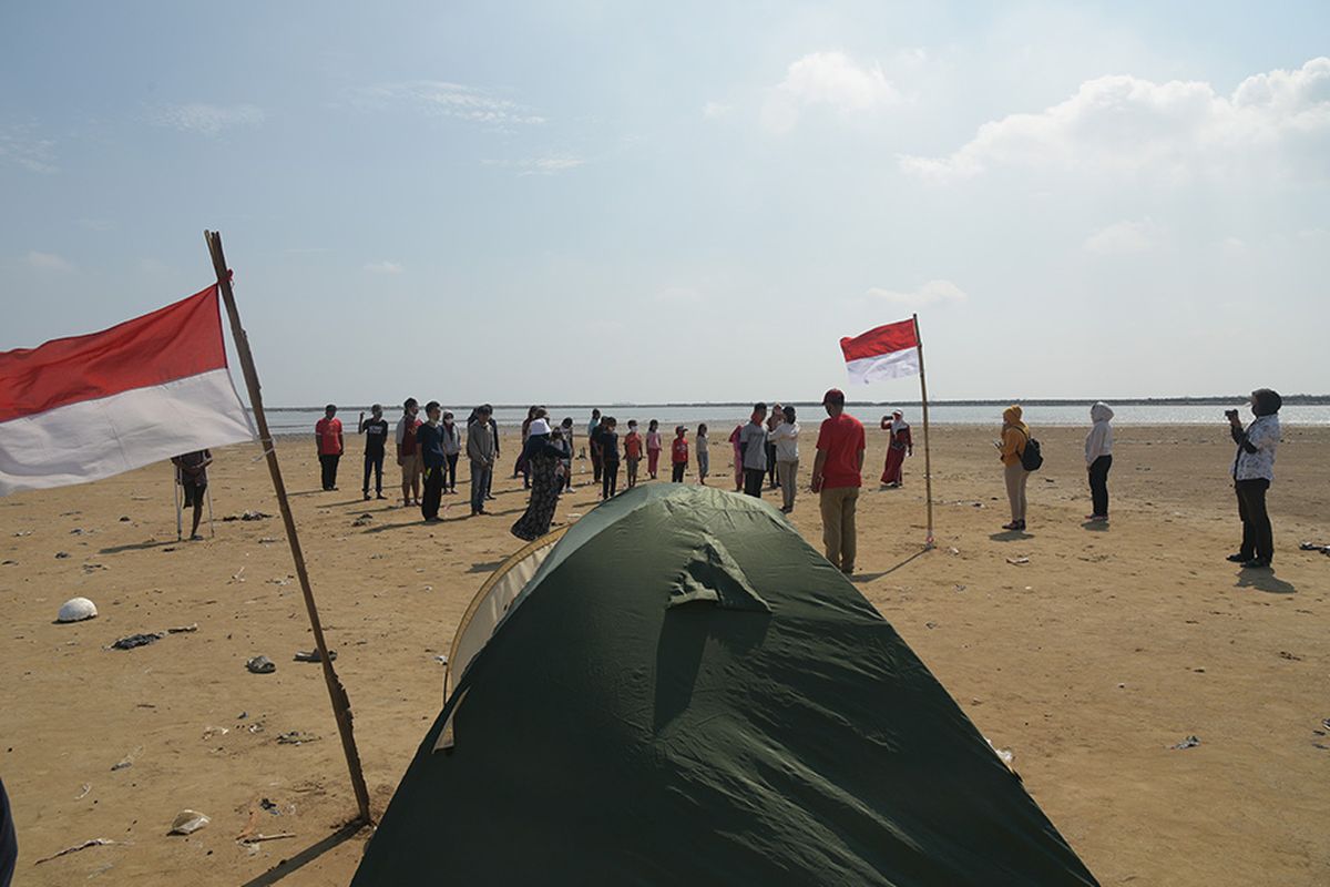 Sejumlah warga melaksanakan upacara bendera dan peringatan detik-detik proklamasi di lahan reklamasi di kawasan Cilincing, Jakarta Utara, Senin (17/8/2020).