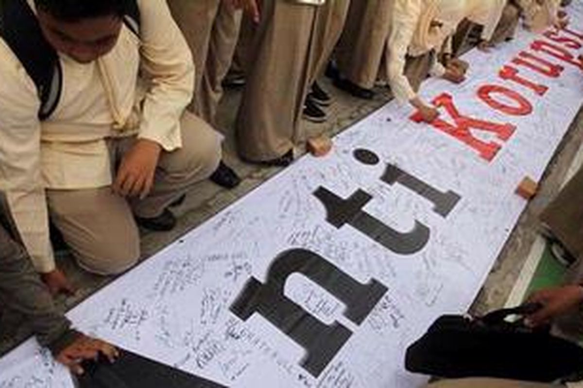 Siswa SMAN 13 Koja, Jakarta membubuhkan tanda tangan dan pesan moral pada spanduk dukungan antikorupsi di pelataran sekolah mereka, Jumat (19/10/2012). Dalam kesempatan tersebut, siswa SMAN 13 juga mendeklarasikan seruan dukungan moral kepada KPK. Mereka mendesak Presiden Susilo Bambang Yudhoyono beserta seluruh lembaga dan aparat penegak hukum terus berkomitmen memberantas korupsi.  