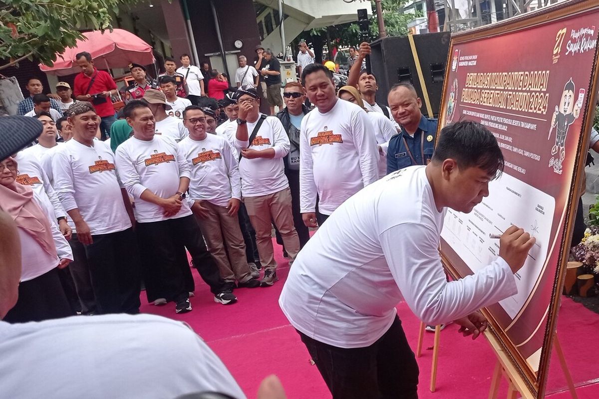 Ketua Bawaslu Kabupaten Magetan Muhamad Kilat Adinugroho Syaifullah saat menandatangani plakat kampanye damai dalam kegiatan kampanye damai di pasar Baru Magetan.  