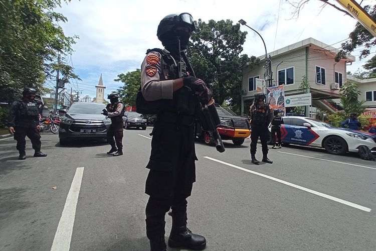 Petugas kepolisian berjaga di lokasi dugaan bom bunuh diri di depan Gereja Katedral Makassar, Sulawesi Selatan, Minggu (28/3/2021). ANTARA FOTO/Abrian Abhe/wpa/foc.