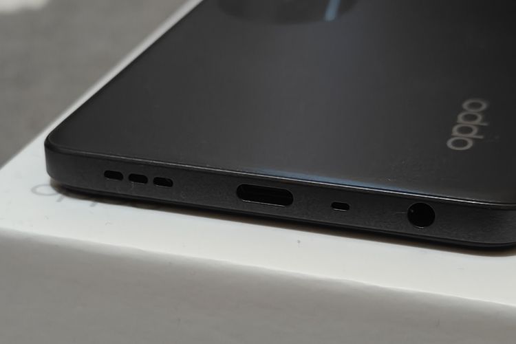 Bagian bingkai bawah Oppo A58 4G. Pada bagian bawah perangkat, terdapat lubang audio jack 3.5 mm, lubang mikrofon, konektor USB-C, dan lubang speaker
