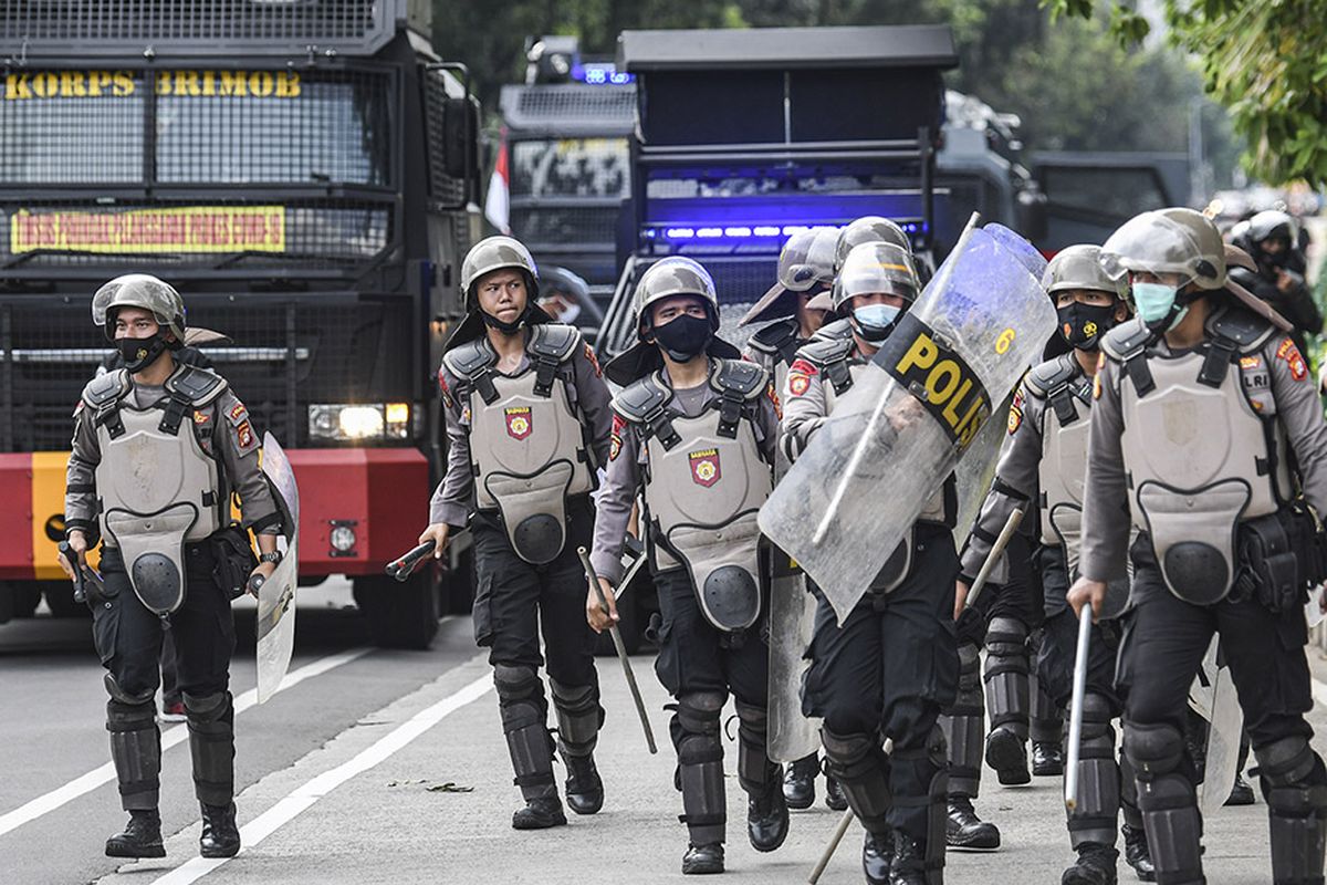 Sejumlah personel polisi bersiap untuk membubarkan massa aksi demonstrasi 1812, di kawasan Medan Merdeka Selatan, Jakarta, Jumat (18/12/2020). Kepolisian membubarkan paksa massa aksi demonstrasi dikarenakan angka penyebaran Covid-19 masih tinggi di wilayah Jakarta.