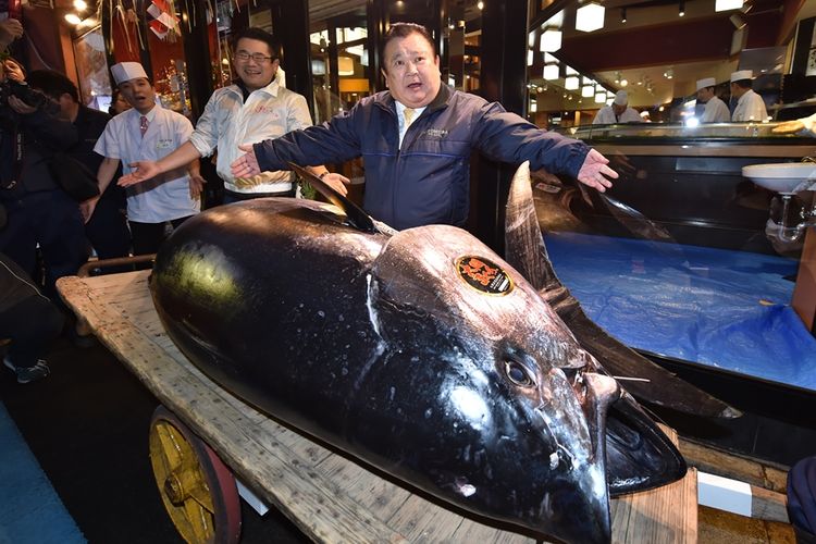 Pengusaha restoran sushi ternama di Jepang, Kiyoshi Kimura, bersama ikan tuna yang dibelinya seharga 3,1 juta dollar AS dalam lelang di Pasar Ikan Toyosu, Sabtu (5/1/2019).
