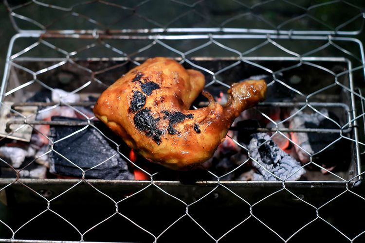 Ilustrasi proses membakar ayam di atas bara api. 