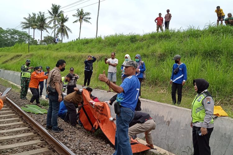 Petugas kepolisian dan BPBD Kabupaten Malang saat melakukan evakuasi remaja yang tewas akibat tertabrak kereta api di Desa Karangkates, Kecamatan Sumberpucung, Kabupaten Malang, Minggu (25/12/2022).