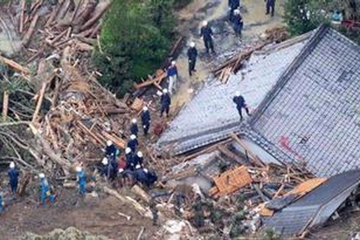 Anggota tim SAR mencari korban di antara reruntuhan rumah dan pepohonan yang tumbang akibat Topan Talas di Tanabe, Jepang, Senin (5/9/2011).