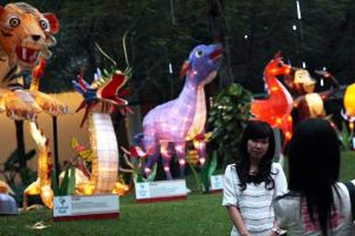 Pengunjung berfoto di depan lampion 12 shio yang dipamerkan di Taman Tribeca yang terdapat di Pusat Perbelanjaan Central Park, Jakarta Barat, Kamis (31/1/2014). Menjelang perayaan Imlek, pusat-pusat perbelanjaan di Jakarta mulai menghias diri.