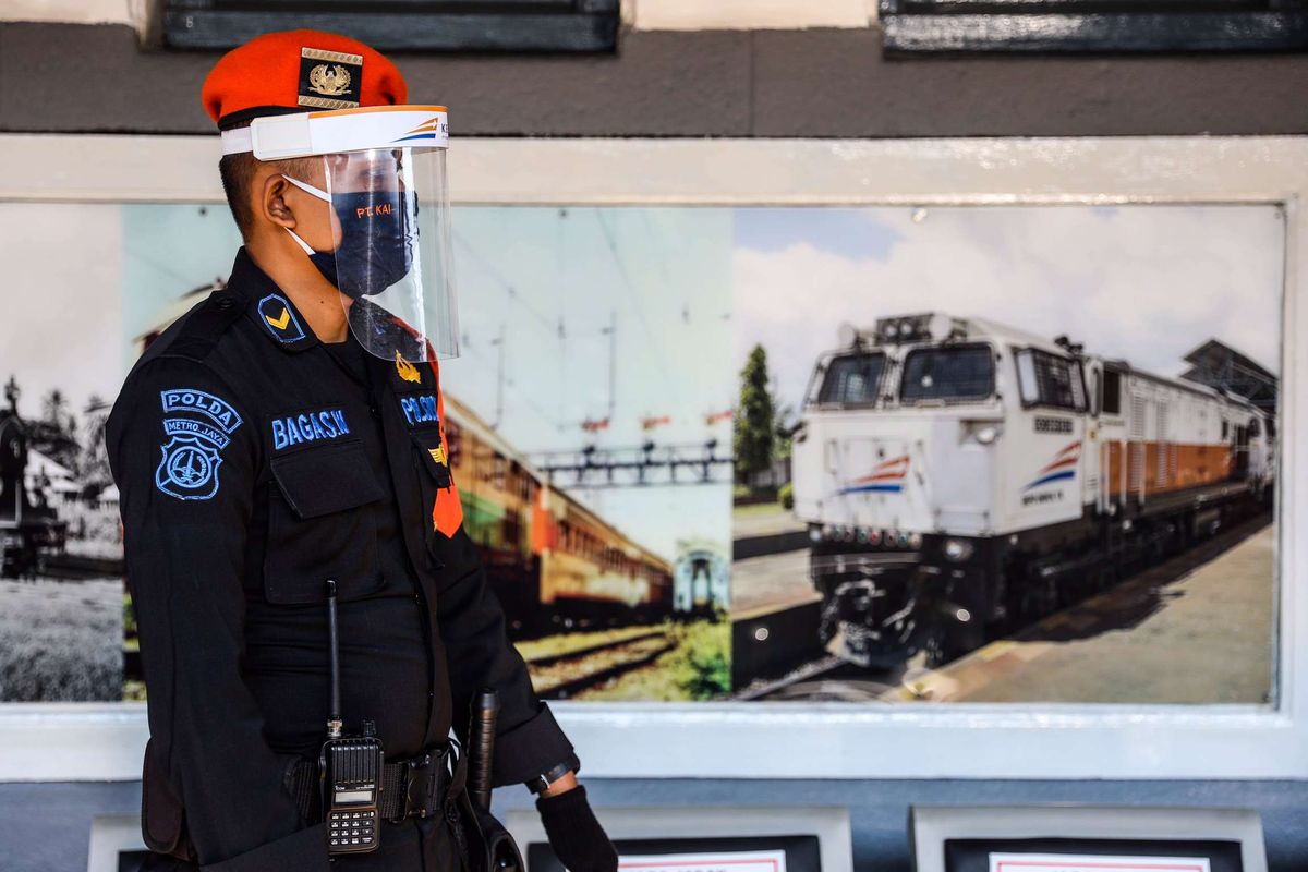 Petugas berjaga di dekat rangkaian Kereta Api (KA) Serayu di Stasiun Pasar Senen, Jakarta Pusat, Jumat (12/6/2020). Kereta Api Jarak Jauh Reguler kembali beroperasi dan ada satu kereta yang diberangkatkan yakni dari Stasiun Pasar Senen menuju Stasiun Purwokerto di Jawa Tengah, pengoperasian diikuti dengan penerapan protokol pencegahan COVID-19.