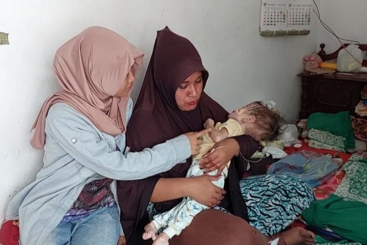 Anisa Maharani bersama ibunya Lina Handayani (37) yang menggendong adiknya yang alami gizi buruk di sebuah rumah kontrakan di Kelurahan Kalinyamat Kulon RT 05 RW 03, Kecamatan Margadana, Kota Tegal, Sabtu (27/5/2023)