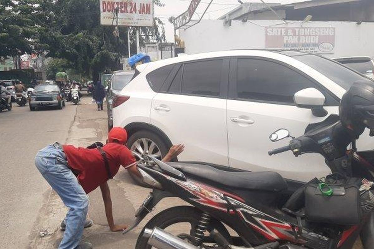 Aziz, penyandang disabilitas yang menjadi juru parkir di Jalan Pahlawan Revolusi, Pondok Bambu, Jakarta Timur