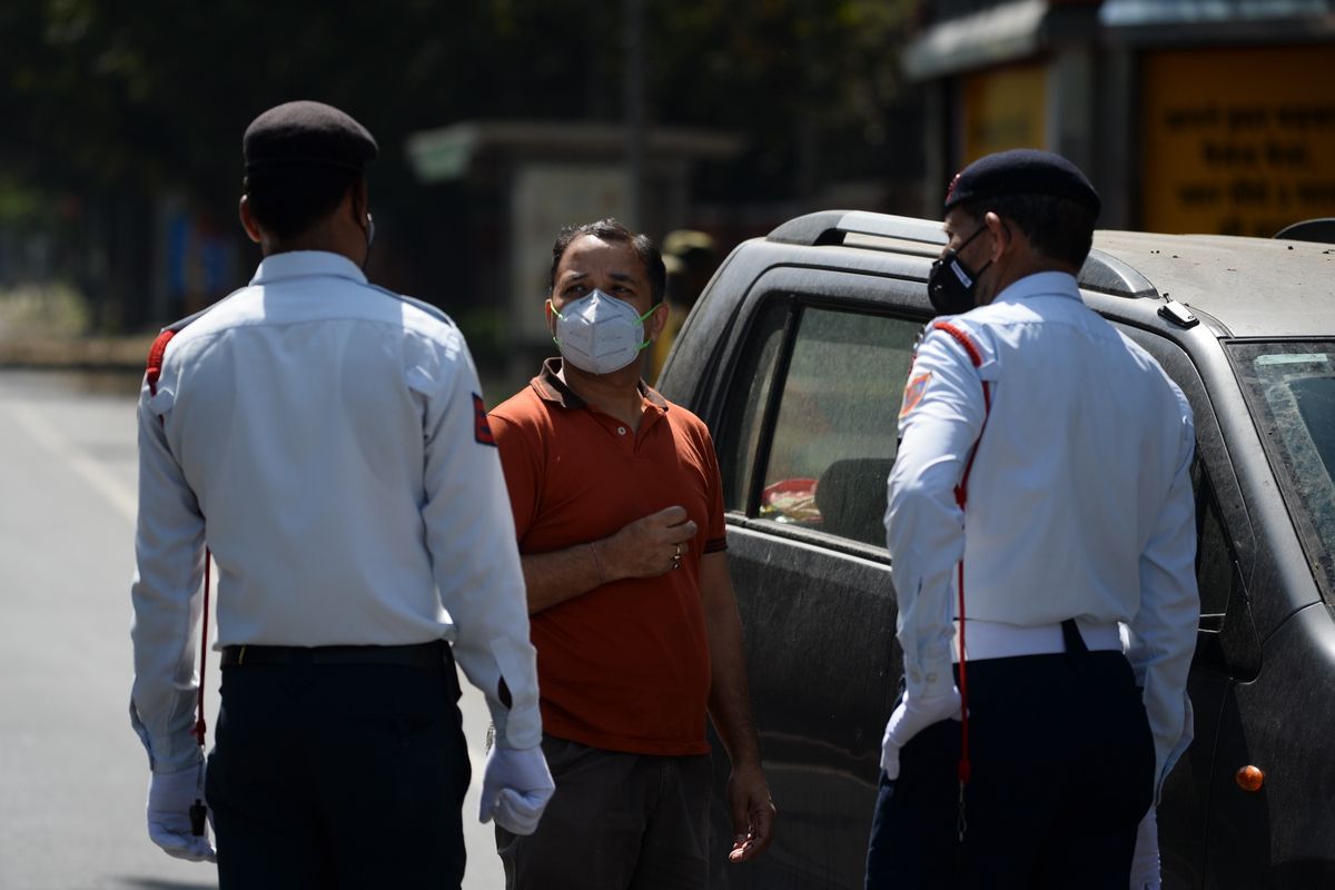 Petugas keamanan di New Delhi memeriksa pengendara pada hari pertama pemberlakuan karantina atau lockdown di seluruh wilayah di India, Rabu (25/03/2020). Perdana Menteri India Narendra Modi mengumumkan, negaranya memasuki masa lockdown total selama 21 hari untuk memerangi virus corona.