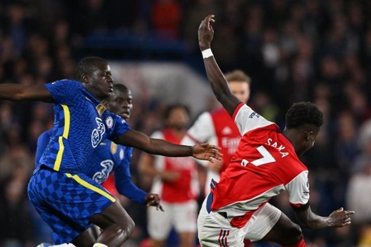 Pemain Arsenal, Bukayo Saka, terlibat duel perebutan bola dengan bek Chelsea, Malang Sarr, dalam laga Liga Inggris 2021-2022 di Stamford Bridge, 20 April 2022.