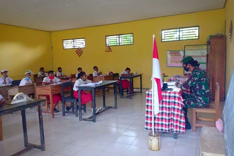 Anggota TNI Satuan Tugas Pengamanan Perbatasan Indonesia-Timor Leste dari Pos Yonarmed 6/3 Kostrad, membantu menjadi pengawas ujian akhir semester (UAS), Selasa (4/5/2021)