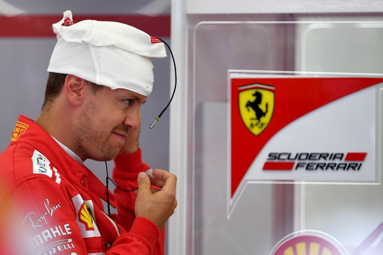 Pebalap Ferrari asal Jerman, Sebastian Vettel, bersiap sebelum menjalani sesi latihan pertama GP Bahrain di Sirkuit Internasional Bahrain, Sakhir, Jumat (14/4/2017).